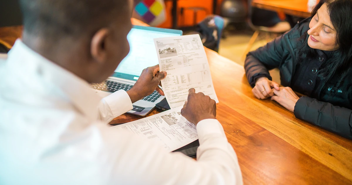 Deux professionnels face a face lors d'un premier RDV commercial, bloc-notes ouvert, illustrant la qualification prospect en vente B2B.
