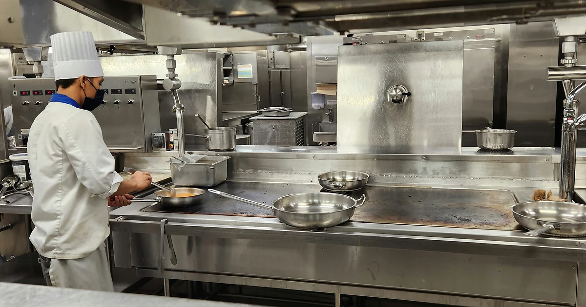 Expert en hygiène alimentaire accompagnant un professionnel sur les contrôles HACCP en cuisine professionnelle